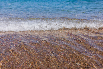 Beautiful view of rolling waves on sandy beach of  sea.