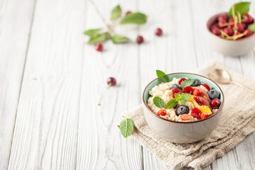 Oatmeal cereal with berries in a bowl on the table. A healthy breakfast. Baby food.