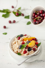 Oatmeal cereal with berries in a bowl on the table. A healthy breakfast. Baby food.