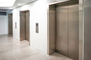 Three elevator doors in office building. Wide angle view of modern elevators with doors. Elevators...