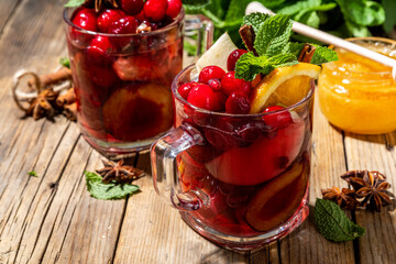 Christmas mulled wine with aromatic spices and citrus fruits and berry. Hot autumn winter fruity punch drink with red wine, on old rustic wooden background copy space 