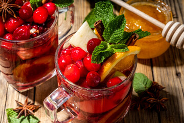 Christmas mulled wine with aromatic spices and citrus fruits and berry. Hot autumn winter fruity punch drink with red wine, on old rustic wooden background copy space 