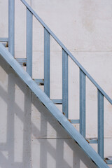 Outside steel staircase structure on gray smartboard wall background in house construction site