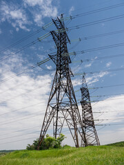 High voltage towers with wires, on a hill in the countryside, on a summer day. Close-up