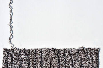 Dissolve hand knitted knitwear made of thick yarn with a braid pattern. edge of knitting with open...