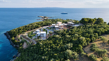Fototapeta na wymiar Aerial view of houses and villas in a resort town Sivota in Greece. Real estate and urban development concept. Aerial view at Ionian Coast in Epirus region, Mediterranean, Greece