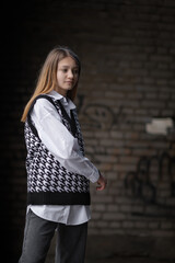 Portrait of a young beautiful girl in a woolen black and white jacket.