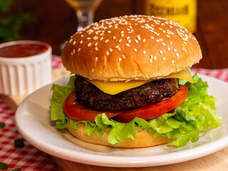 Burger with salad and cheese, with beer on wooden table