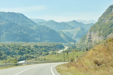 An asphalt road or highway without transport going into the distance to the mountains. The concept of travel and adventure.