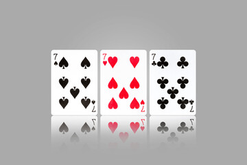 Three sevens. Playing cards on a gray background. Reflection. Gambling.
