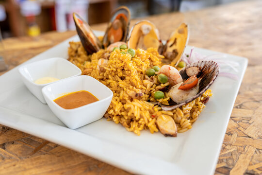 A view of a shrimp fried rice, in a restaurant or kitchen setting. wooden background