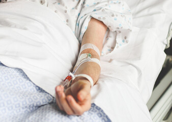 The hand of a caucasian young patient with a dropper in the vein