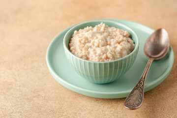 Oatmeal porridge  in a bowl on a table. Healthy food