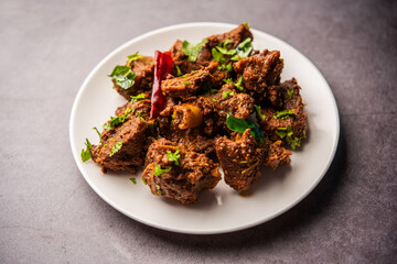 Sukha mutton or chicken, dry spicy Murgh or goat meat served in a plate or bowl