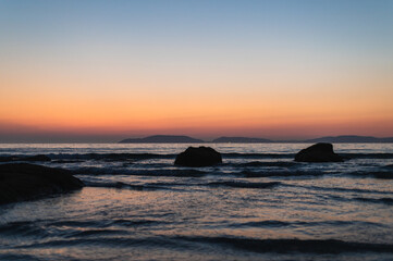 Fototapeta na wymiar sunset on the beach with mountains