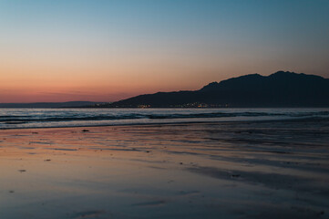 sunset on the beach with mountains