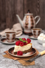Homemade cheesecake decorated with raspberries and a retro coffee set on a gray table. Coffee still life in vintage style.