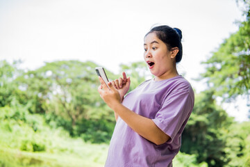 Shocked Asian woman taking pictures like with a phone