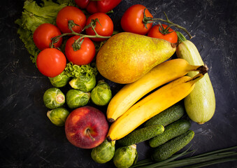 Different vegetables and fruits on a dark background