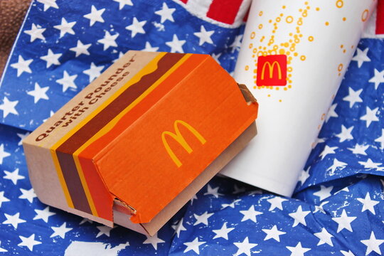 Washington, USA - July 07 2022 : McDonald's Soft Drink Glass and a box of McDonald's burgers Placed on American flag star pattern cloth, McDonald's is a popular food for Americans.