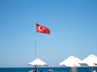 Flaga Turcji powiewająca nad morzem, plaża 