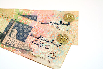 Obverse sides of an old 100 LE EGP one hundred Egyptian cash money banknote features Al-Sayida Zainab mosque in Cairo at centre, selective focus of withdrawn Egyptian Pound banknotes isolated on white