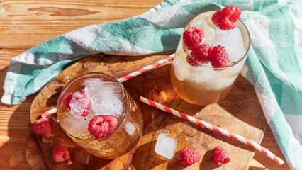 2 Cup Ice tea with raspberries and ice cubes.