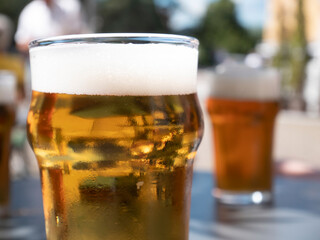 small beer, two glasses of beer on the table outside blurred background