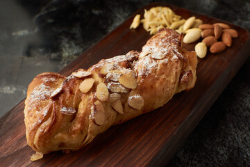 French artisan bread, almond tie name bread placed on a wood and almonds to the side