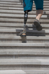 A man with a bionic prosthetic leg left side goes up the stairs