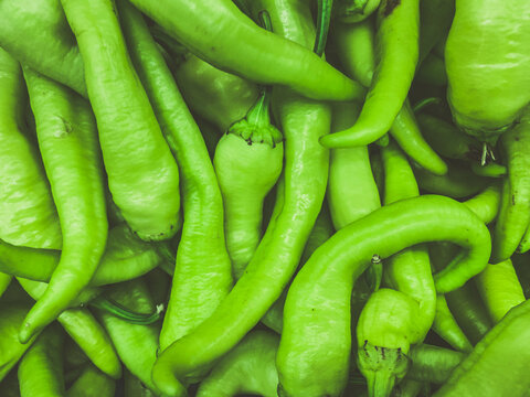green peppers, natural background. farm products. vitamin vegetables, healthy vegan foods. pepper has a green hook on its tail