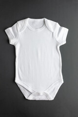 Flat lay of a white bodysuit made of natural fabric - basic clothing for newborn girls and boys on...
