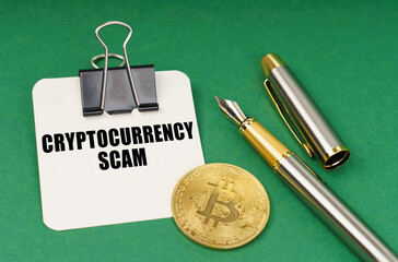 On a green surface, a bitcoin coin, a pen and a sheet of paper with the inscription - Cryptocurrency scam