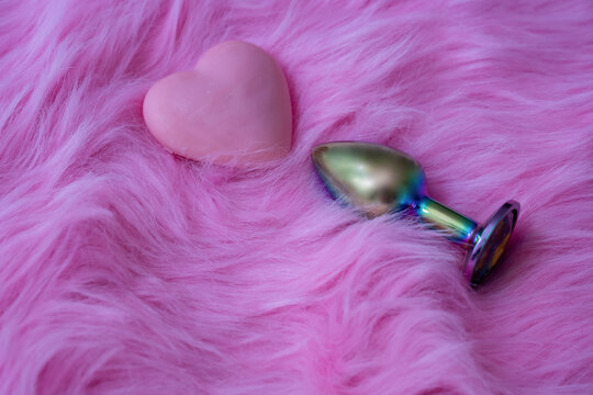 anal butt plug sex toy on fur pink background, sex shop advertisement 