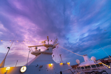 A colorful sunset sky of purple, blue and pink above a cruise ship at the Livorno, Italy cruise...