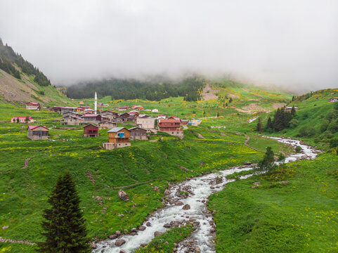 Rize, Elevit Plateau. A village with a mountain river flowing nearby, houses with a red roof at the foot of the mountains, a foggy background. Rize Kakar Mountains region, Turkey. Selective focus
