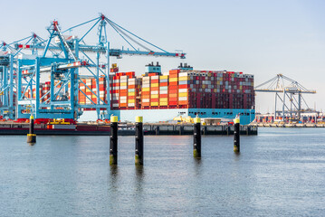 Large container ship being loaded while moored to a commercial dock