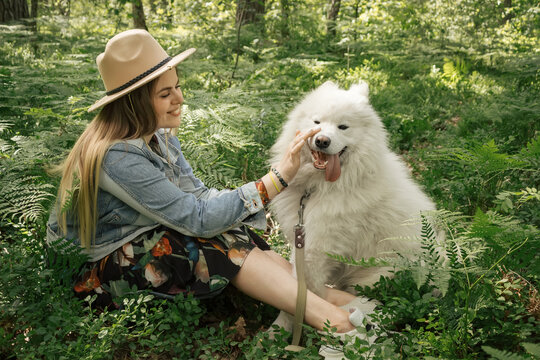 Woman spanding time with her fluffy dog samoyed