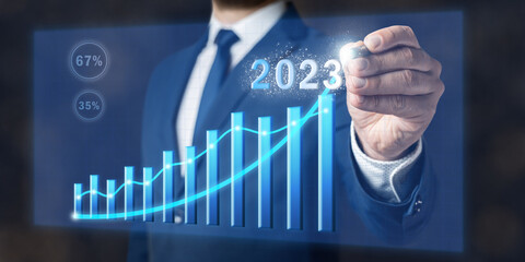 Concept of increase business in 2023 year, businessman draws graph, planning new strategy of growth, goals and opportunities, virtual screen