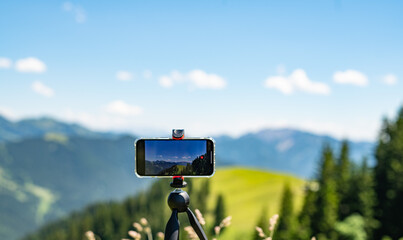Smartphone auf Stativ filmend das Gebirge der Alpen
