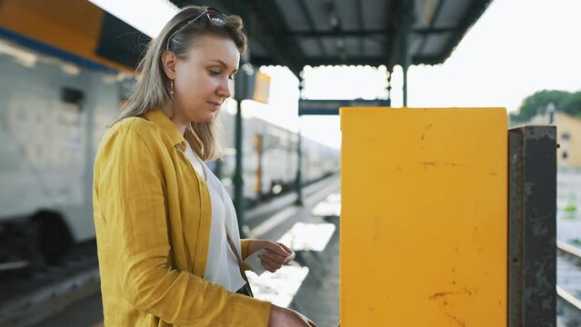 Woman validates a train ticket in Italy.