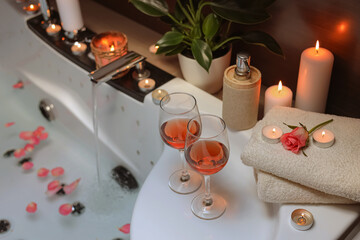 Bathtub with glasses of wine and candles indoors. Romantic atmosphere
