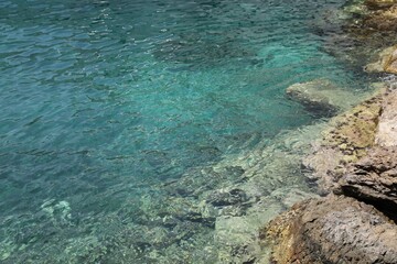 Shallow water with rocky sea bottom as background