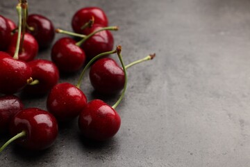 Many sweet cherries on grey table, space for text