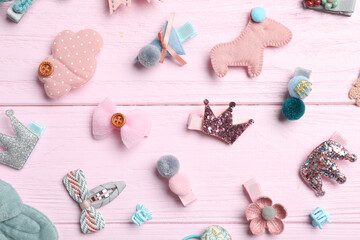 Cute hair clips on pink wooden table, flat lay