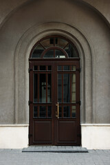 Entrance of house with beautiful arched wooden door and transom window