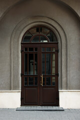 Obraz premium Entrance of house with beautiful arched wooden door and transom window