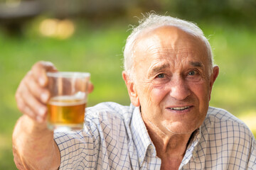 senior man toasting happy outdoors