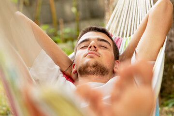 young man sleeping in the hammock in summer