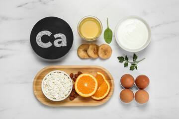 Set of natural food high in calcium on white marble table, flat lay